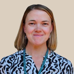 Photo of staff Member Lexi H. Image of woman smiling with short blonde hair. Woman is wearing a black and white shirt.