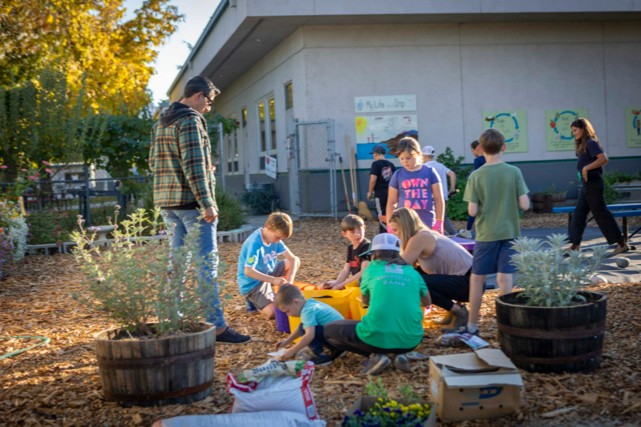 children and parents working together and planting flowers.